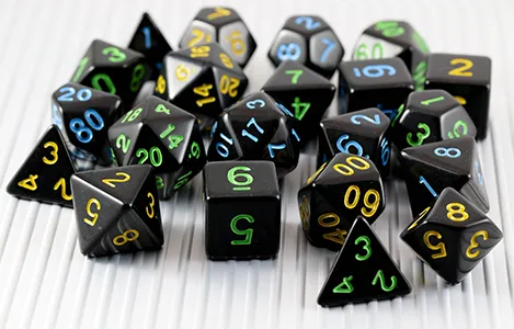 A scattered set of high-gloss black polyhedral tabletop gaming dice showing varied numerical facets.